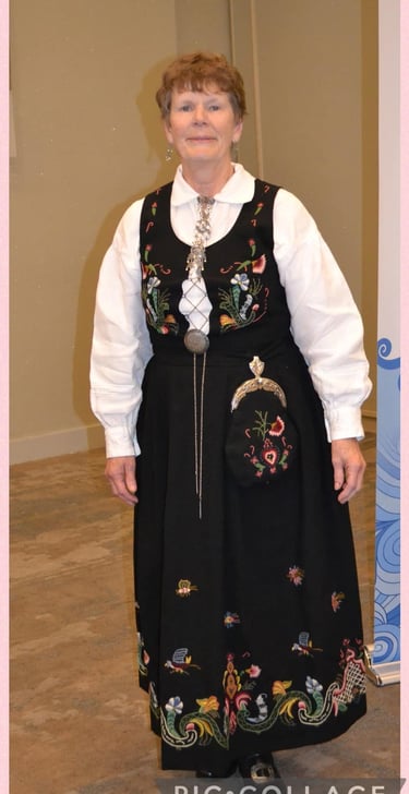 A woman in a blue embroidered bunad