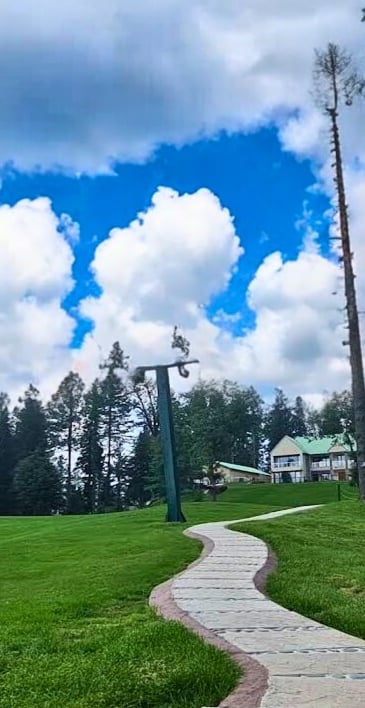 a path leading to a grassy field with a path leading to a house at greenspot nathiagali