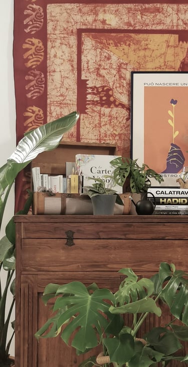 a dresser with a large tapestry hanging on a wall