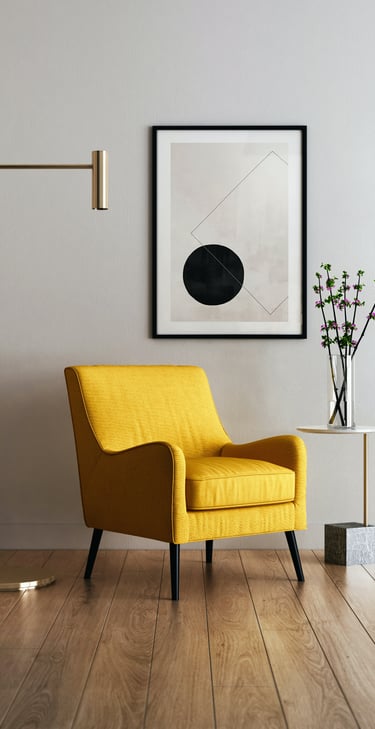 Sillón amarillo moderno en un salón con suelo de madera, lámpara dorada y cuadro geométrico.
