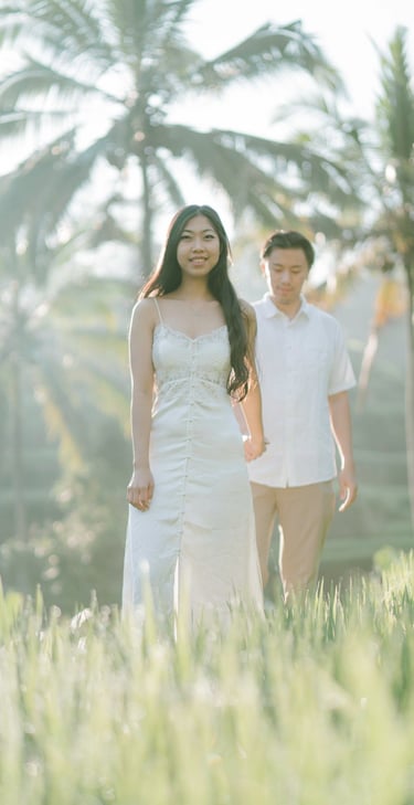 Couple walking through the rice field during a sunrise photography session at Tegalalang Ubud Bali.