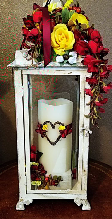 A holder and candle with flowers and heart.