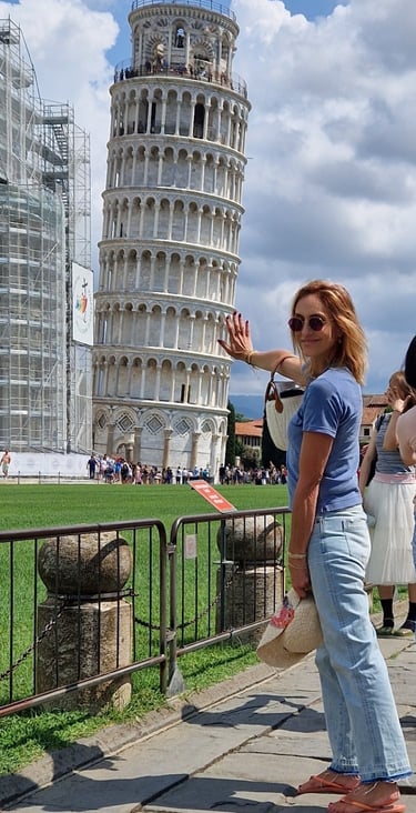Mary Tornariti posing in front of the Leaning Tower of Pisa, Italy.