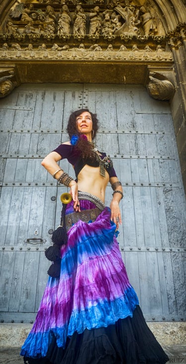 a woman in a colorful dress with a belly belt