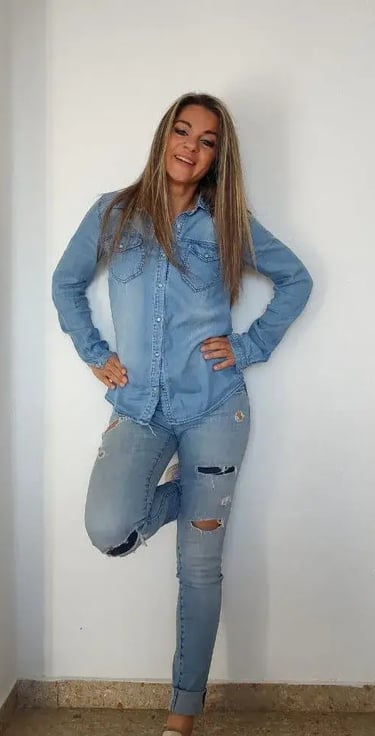 Sandy votre assistante debout contre un mur blanc