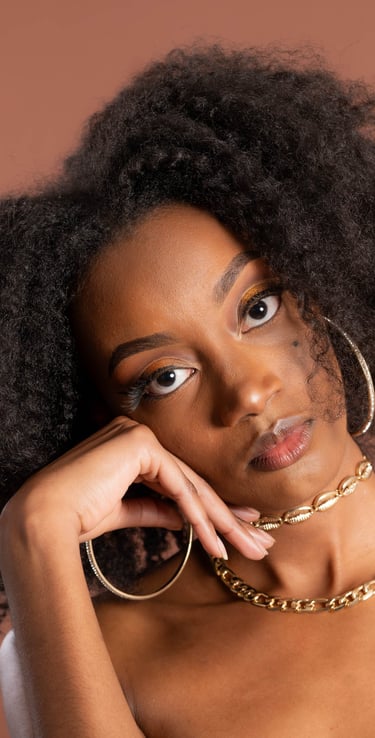 a woman with a large afro - like hair and a gold chain link bracelet