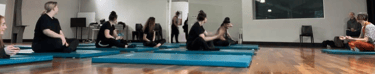 a group of people sitting on yoga mats