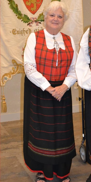 a woman in a red plaid festdrakt with a solje