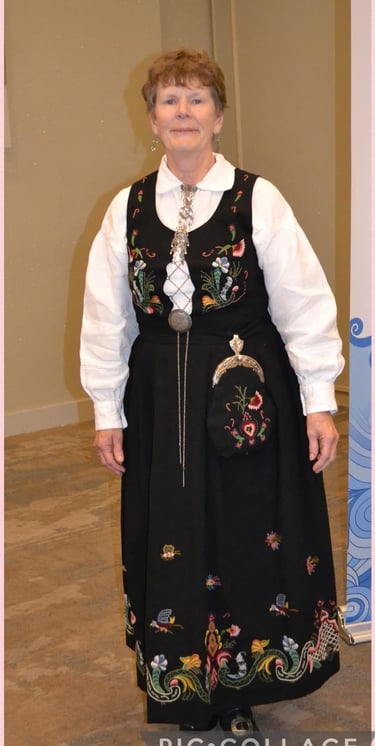 A woman in a blue embroidered bunad