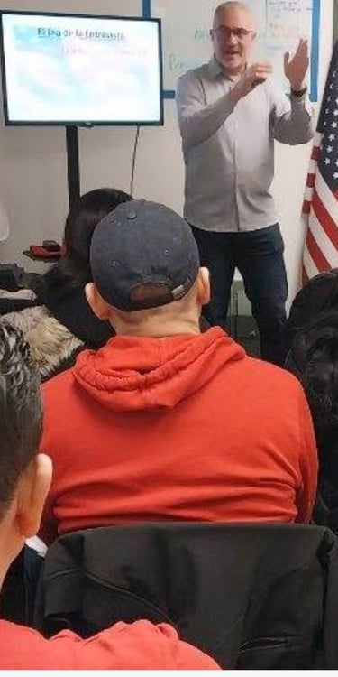 a man in a red jacket is giving a presentation