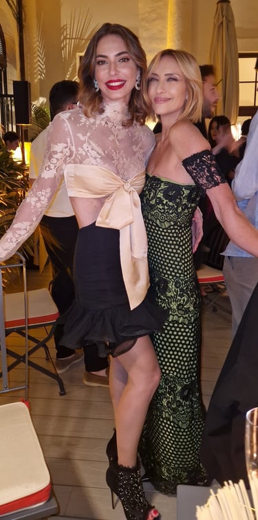 Mary Tornariti at a Rome evening event in a green lace gown with a friend.