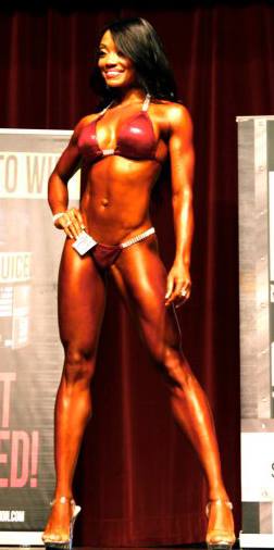 Bikini prep coach Melbourne female athlete posing onstage by Body Matrix Gym — contest prep results