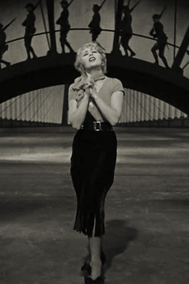 Joan Blondell singing “Remember My Forgotten Man” with WWI soldiers on a dramatic stage bridge.