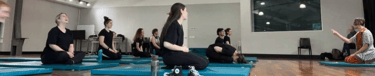 a group of people sitting on blue mats in a gym