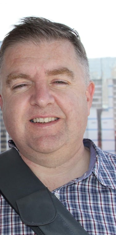 Two adults posing inside observation wheel cabin with city skyline in background, capturing a moment of leisure