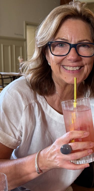 Two adults smiling at restaurant table with drinks and candle, enjoying relaxed social outing