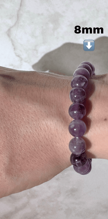 The first half a photo of a wrist with 2 amethyst crystal bracelets on it, this side is the 8mm size