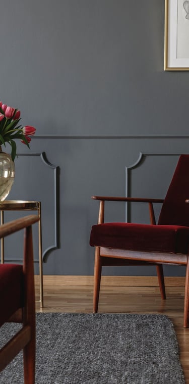 A warm, softly lit consultation room in Calgary with two chairs angled toward each other, a small plant, and a notepad
