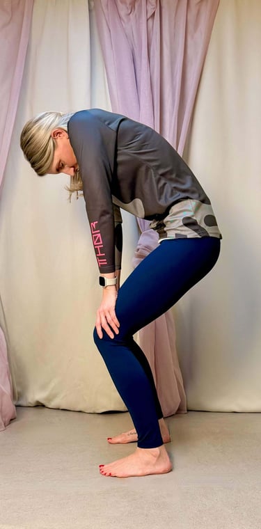Yogalehrerin Anja mit Katzenbuckel im Stehen zur Mobilisierung des Rückens