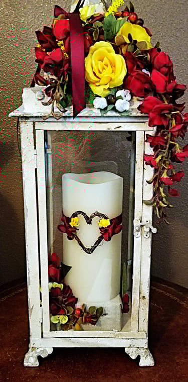 A holder and candle with flowers and heart.
