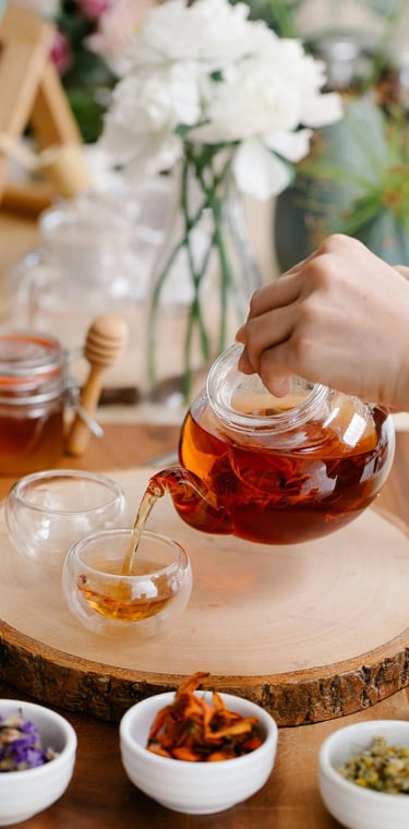 a person pouring tea into a cup