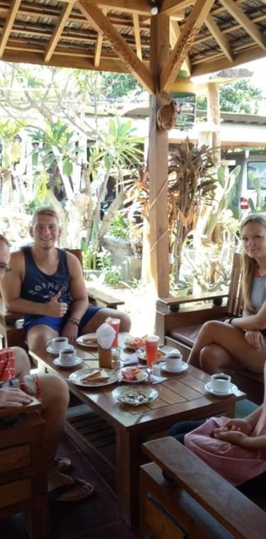 Группа людей сидит за столом и наслаждается завтраком в Sunrise Lodge and Lounge