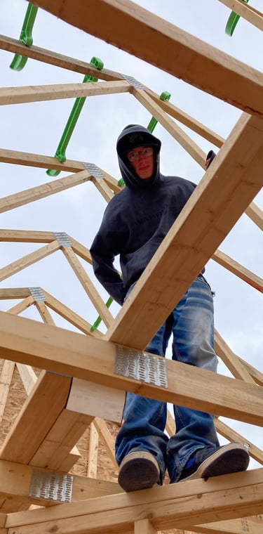 Man standing on roof trusses in Portage Wisconsin