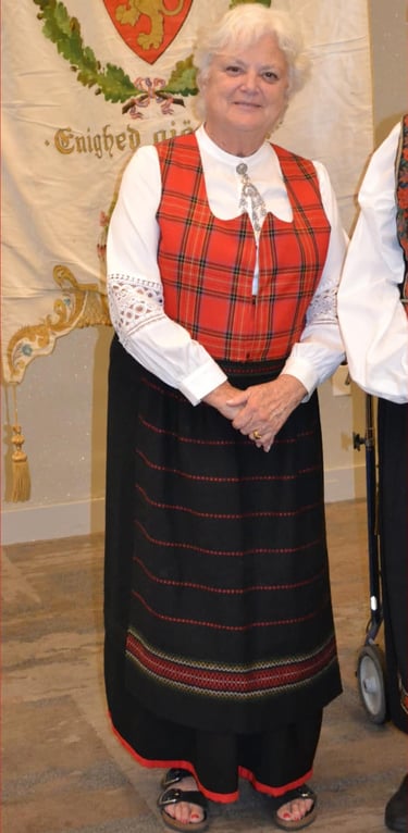 a woman in a red plaid festdrakt with a solje