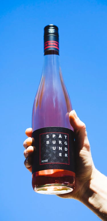 Bottle of rose wine held by a hand.