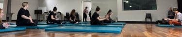 a group of people sitting on yoga mats