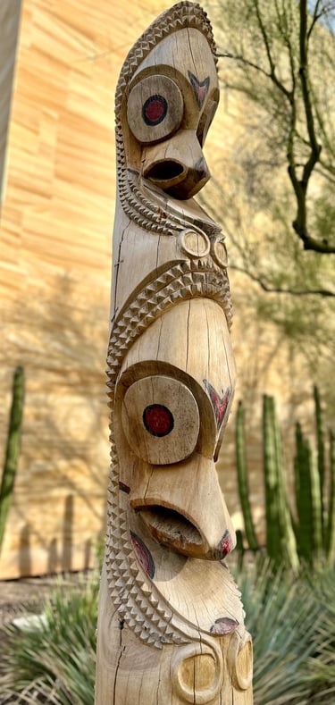 a wooden vanuatuan slit drum with faces carved into it