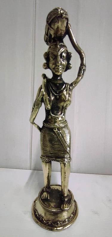 "Brass statue of a woman in attire carrying a pumpkin on her head and tools on her shoulder-For international dispatch