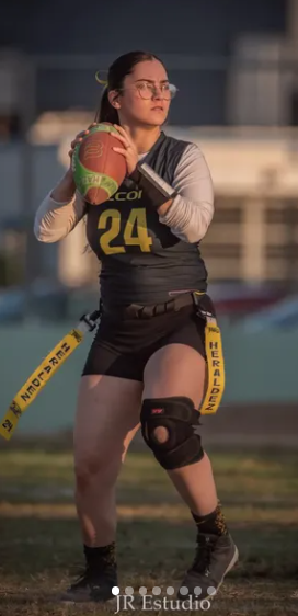 a woman in a black and white uniform holding a football ball