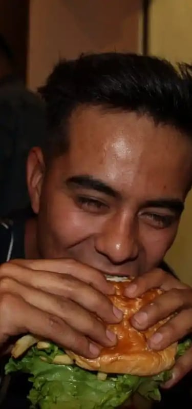 muchacho disfrutando de una jugosa carne de hamburguesa