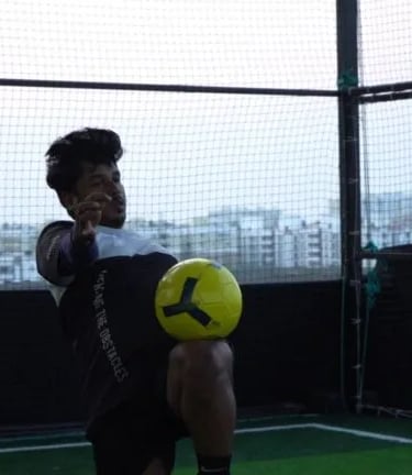 a man holding a soccer ball in a cage