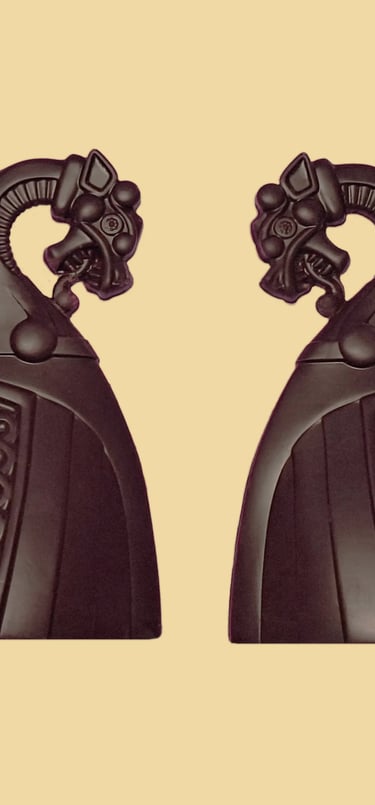 A pair of decorative black Viking ship dragon head in dark chocolate.