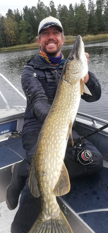 a man holding a pike in a boat 