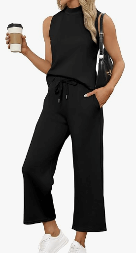 a woman in a black top and pants with a coffee cup