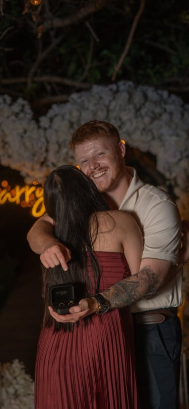 a man and woman embracing in front of a neon sign
