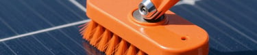 Close-up of specialized soft-brush cleaning equipment in action on a large solar array, bright direct sunlight, deep blue tones, sharp focus, 35mm