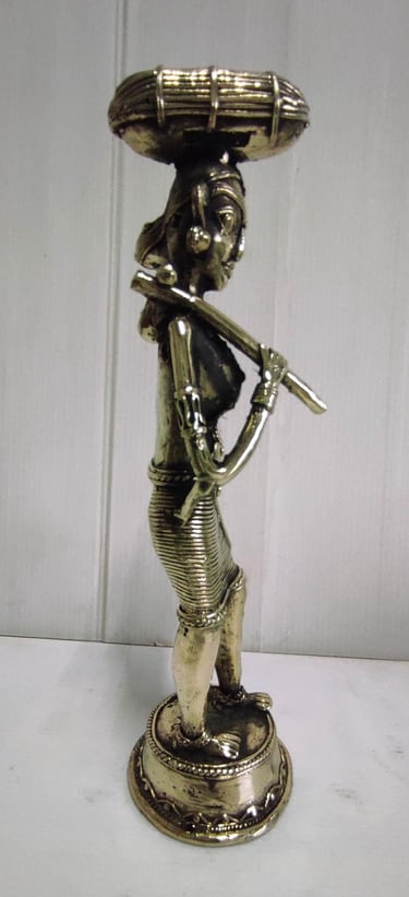 "Brass statue of a woman in attire carrying a pumpkin on her head and tools on her shoulder-For global distribution"