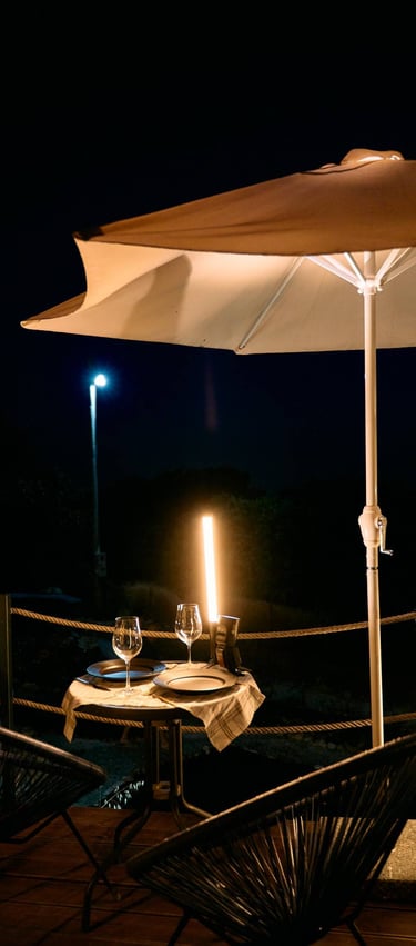 Romantična večera na terasi pod suncobranom i svećama