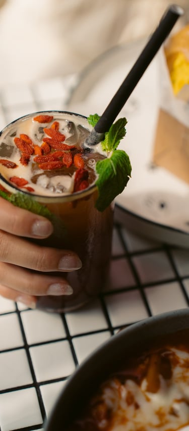a person holding a drink in a glass