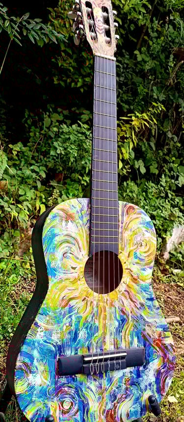 peinture sur guitare aux couleurs vives, avec un soleil autour de la rosace et des formes abstraites