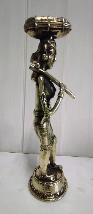 "Brass statue of a woman in attire carrying a pumpkin on her head and tools on her shoulder-For global distribution"