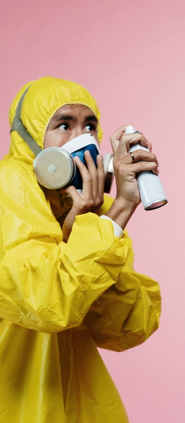 A man in full ppe with a spray bottle