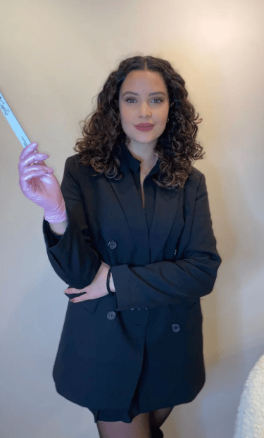 a woman in a black suit and gloves holding a toothbrush