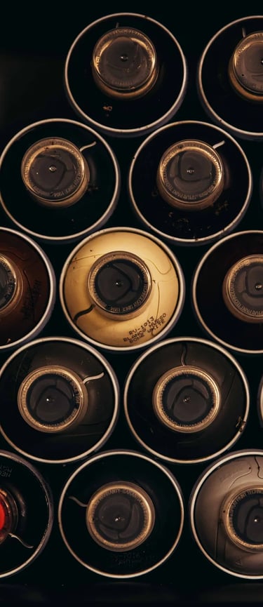 Top-down view of organized colorful spray paint cans in a storage box for graffiti art projects.