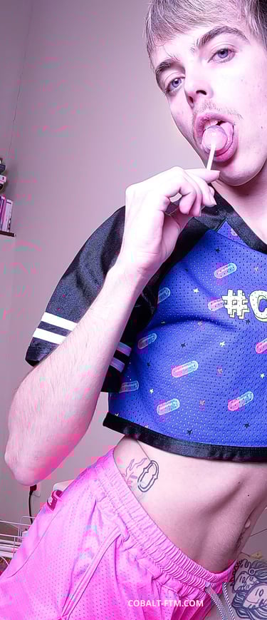 cobalt ftm, ftm twink takes a sexy pose licking a lollipop, wears short shorts and cropped t-shirt