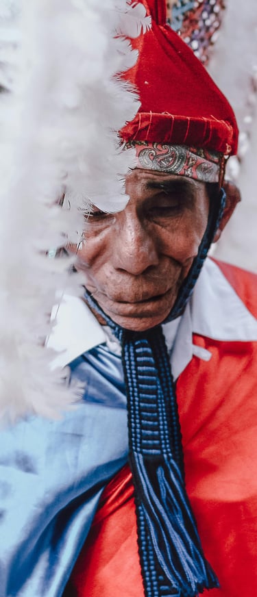 a man in a red and white costume with a feathered headdress